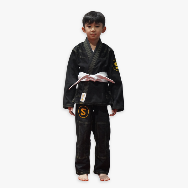 Child wearing a black BJJ uniform with a white belt on a white background